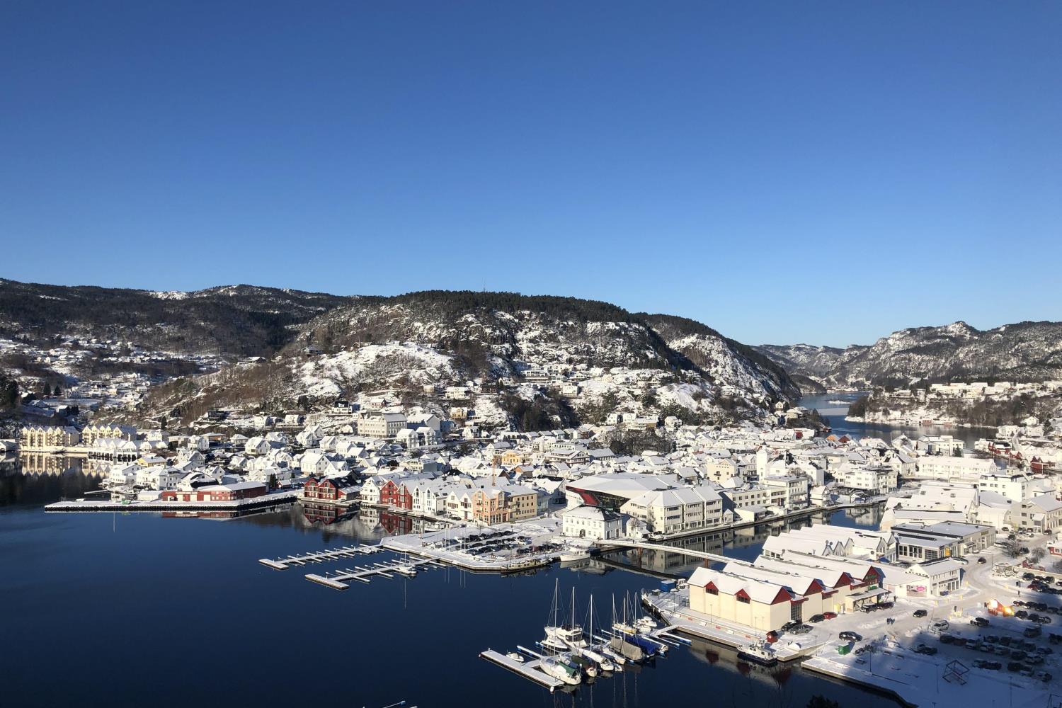 Flekkefjord by dekket av snø med blå himmel i bakgrunnen