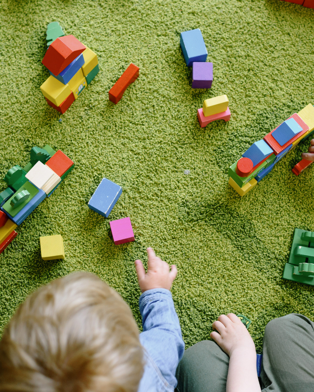 Foto tatt ovenfra av barn som leker med byggeklosser